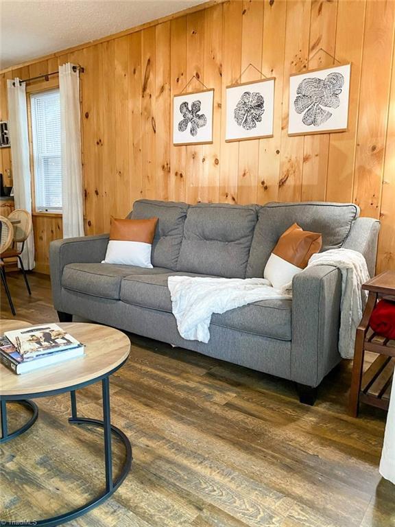living room with wood finished floors and wooden walls