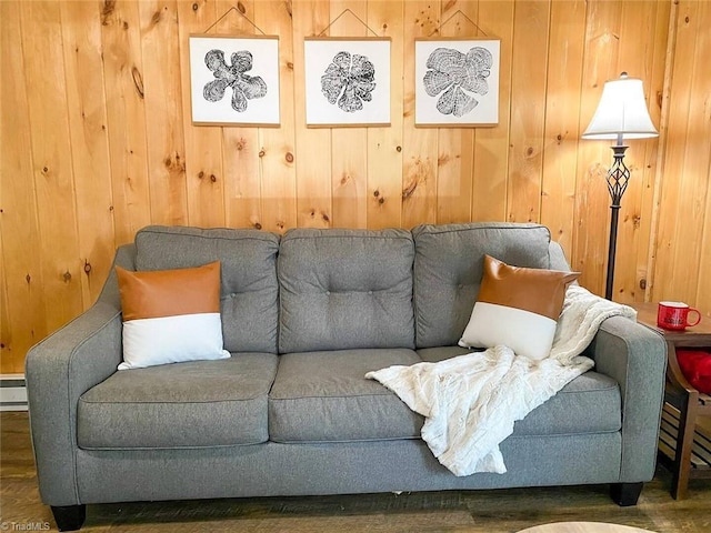 living area featuring baseboard heating, wood walls, and wood finished floors