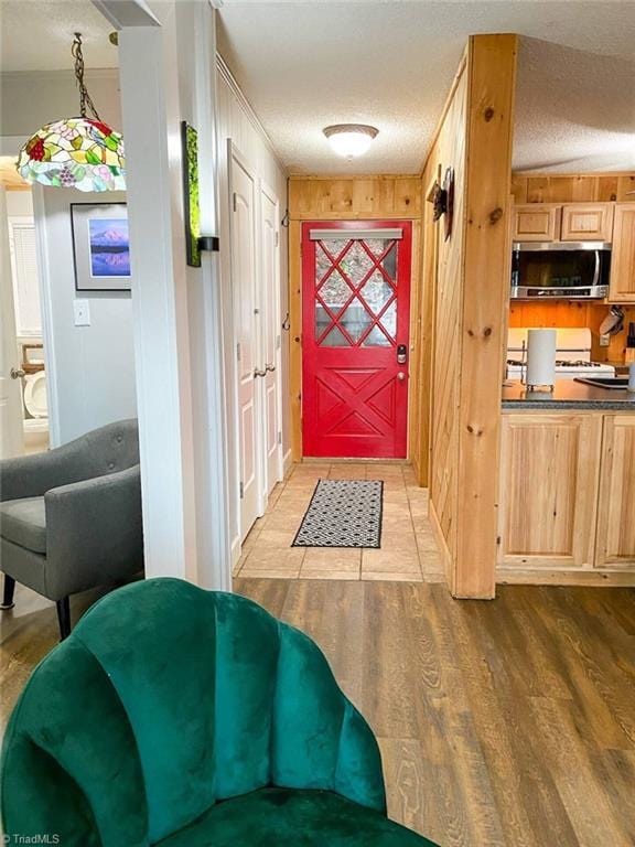 doorway to outside featuring a textured ceiling and wood finished floors