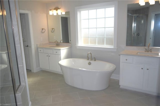 8113 Simon Dr Lot 38, Stokesdale, NC 27357 - bathroom with tile patterned floors, a stall shower, two vanities, a soaking tub, and baseboards