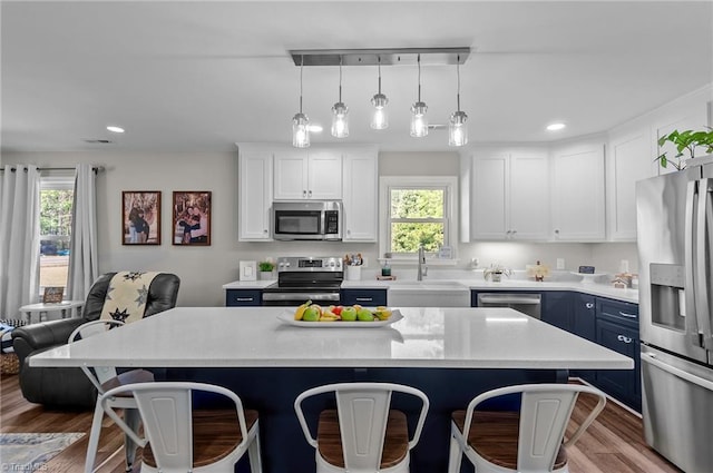 2281 Quarter Rd, Swanquarter, NC 27885 - kitchen featuring stainless steel appliances, a breakfast bar, a sink, blue cabinets, and recessed lighting