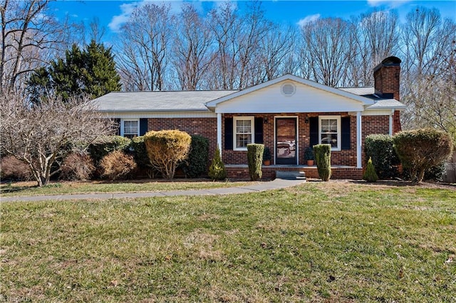 ranch-style house with covered porch, brick siding, a chimney, and a front lawn