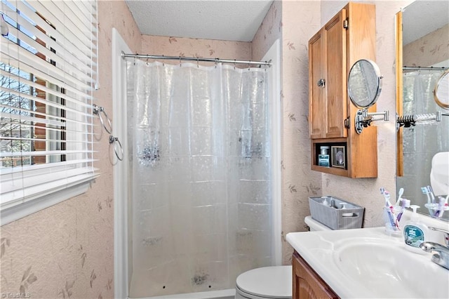 bathroom featuring a textured ceiling, vanity, a shower stall, and toilet