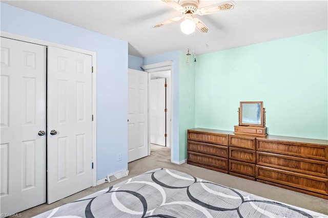 bedroom with light colored carpet, a ceiling fan, baseboards, visible vents, and a closet