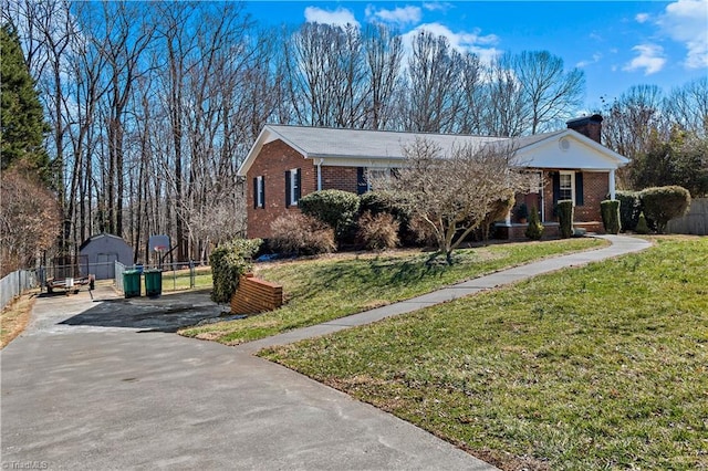 single story home featuring driveway, brick siding, a front lawn, and fence