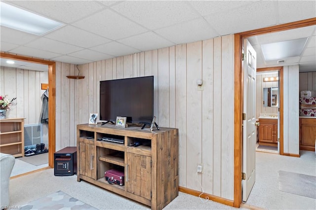 office space with a paneled ceiling and wooden walls