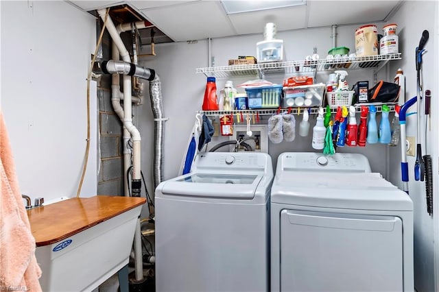 clothes washing area featuring laundry area, a sink, and separate washer and dryer