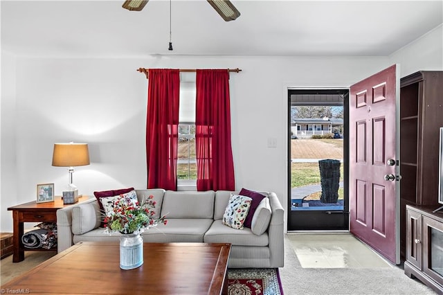 living area with light carpet and ceiling fan