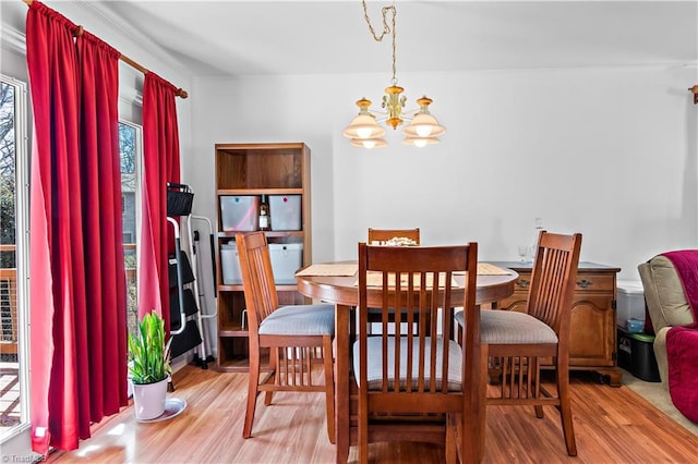 dining space with light wood-style flooring and an inviting chandelier