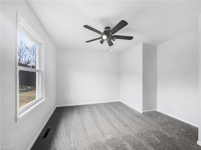 spare room featuring carpet floors, visible vents, ceiling fan, and baseboards