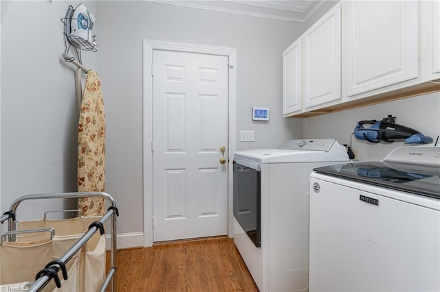 4002 Hobbs Rd, Greensboro, NC 27410 - laundry area featuring washer and dryer, cabinet space, light wood finished floors, and crown molding
