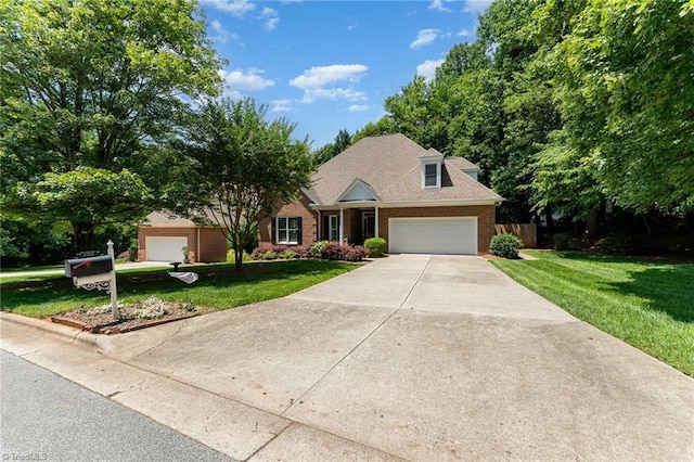 4002 Hobbs Rd, Greensboro, NC 27410 - view of front of home featuring brick siding, a front yard, concrete driveway, and a garage