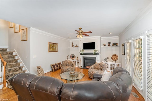 4002 Hobbs Rd, Greensboro, NC 27410 - living room featuring ceiling fan, light wood finished floors, crown molding, a high end fireplace, and stairway