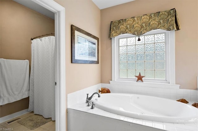 bathroom featuring tile patterned floors, visible vents, a healthy amount of sunlight, and a garden tub