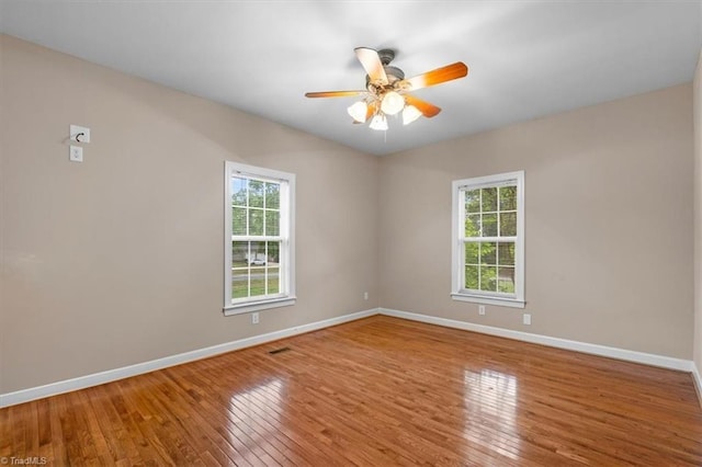 spare room featuring ceiling fan, hardwood / wood-style floors, and baseboards