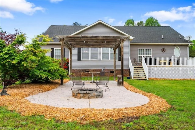 back of house featuring a wooden deck, a patio area, an outdoor fire pit, crawl space, and a lawn