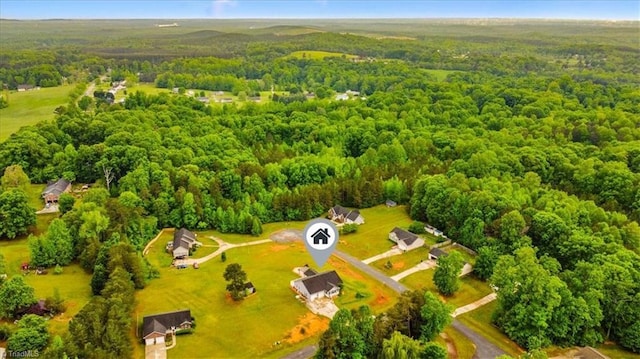 birds eye view of property featuring a forest view