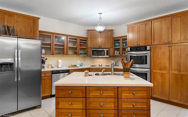 kitchen with stainless steel appliances, light tile patterned flooring, light countertops, and brown cabinets