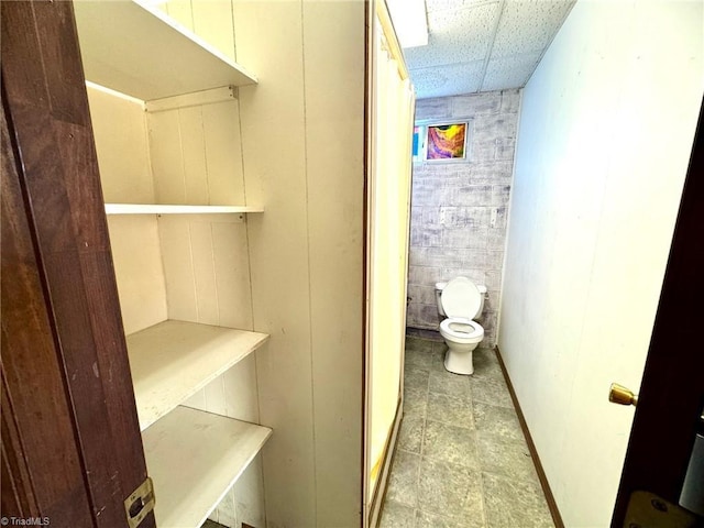 bathroom with toilet and a drop ceiling