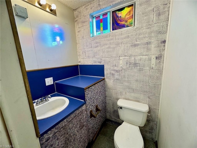 bathroom with tile patterned floors, vanity, tile walls, and toilet