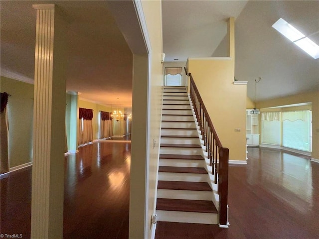 stairway with a chandelier and ornamental molding