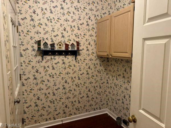 washroom with wallpapered walls and baseboards