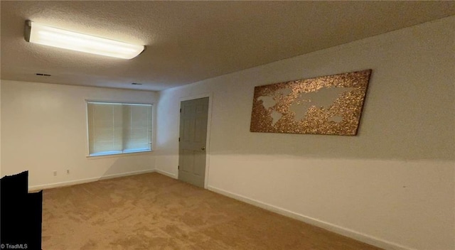 carpeted spare room with baseboards and a textured ceiling