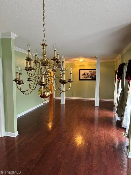 interior space with hardwood / wood-style floors, crown molding, baseboards, and a textured ceiling