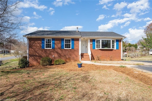 view of front facade with brick siding and a front lawn