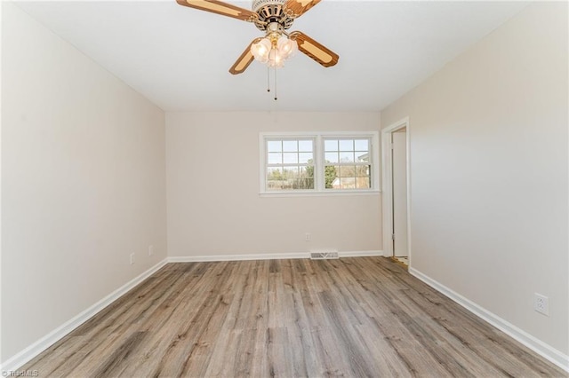 unfurnished room featuring visible vents, a ceiling fan, baseboards, and wood finished floors