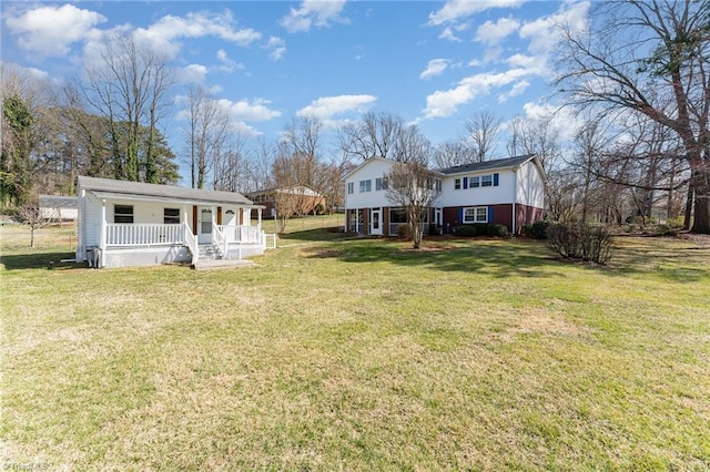 rear view of house featuring a porch and a yard