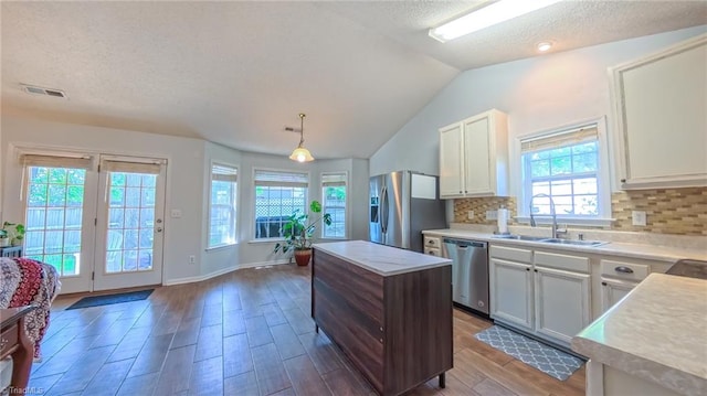 2309 Kasarda Dr, Greensboro, NC 27406 - kitchen featuring appliances with stainless steel finishes, a sink, a textured ceiling, wood finished floors, and light countertops