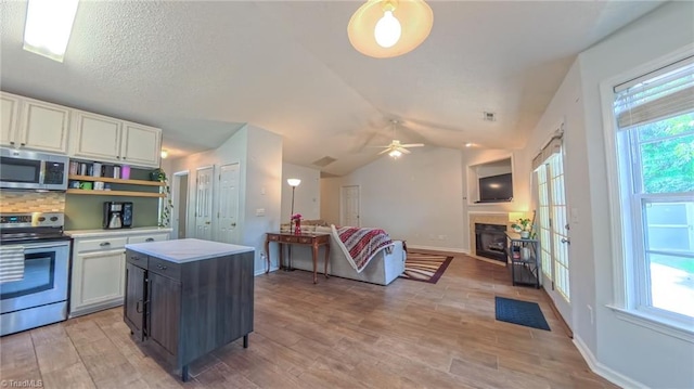 2309 Kasarda Dr, Greensboro, NC 27406 - kitchen featuring stainless steel appliances, light countertops, white cabinets, lofted ceiling, and open floor plan