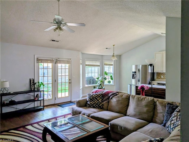 2309 Kasarda Dr, Greensboro, NC 27406 - living area featuring a textured ceiling, plenty of natural light, lofted ceiling, ceiling fan, and light wood-type flooring