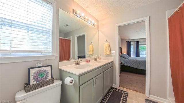 2309 Kasarda Dr, Greensboro, NC 27406 - ensuite bathroom with a textured ceiling, toilet, and double vanity
