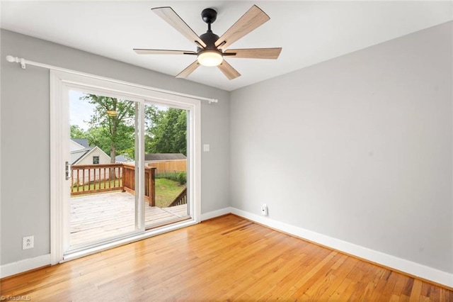 spare room featuring baseboards, wood finished floors, and ceiling fan