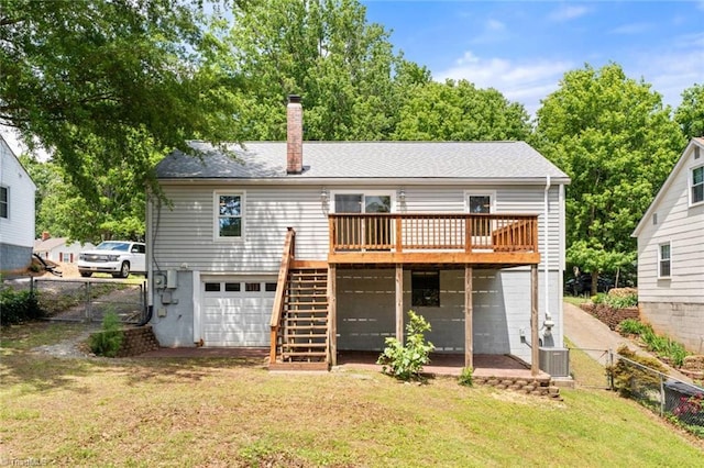 rear view of property with a deck, stairs, a chimney, an attached garage, and a gate