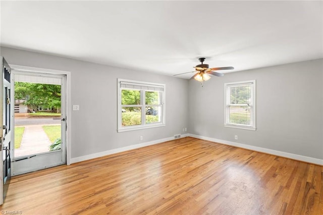 spare room featuring healthy amount of natural light, baseboards, and light wood-type flooring