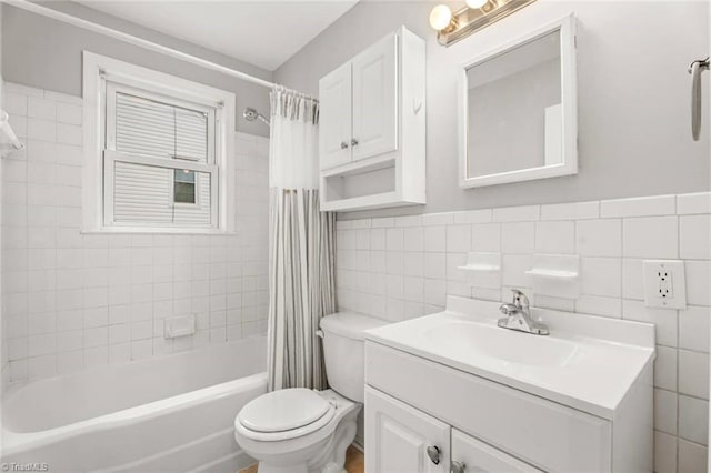 full bath with shower / bath combo, toilet, tile walls, and vanity