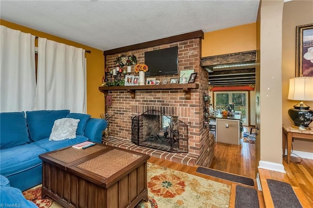 2606 Boone Trl, North Wilkesboro, NC 28659 - living room featuring wood finished floors, a fireplace, and a textured ceiling