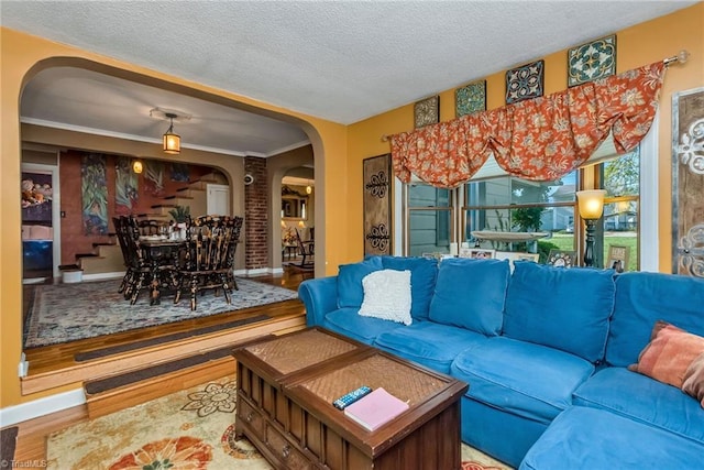 2606 Boone Trl, North Wilkesboro, NC 28659 - living room featuring arched walkways, wood finished floors, baseboards, and a textured ceiling