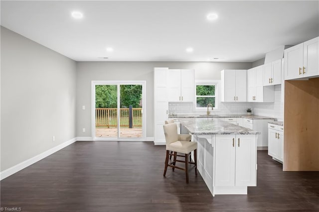 kitchen with white cabinetry, a healthy amount of sunlight, and a center island