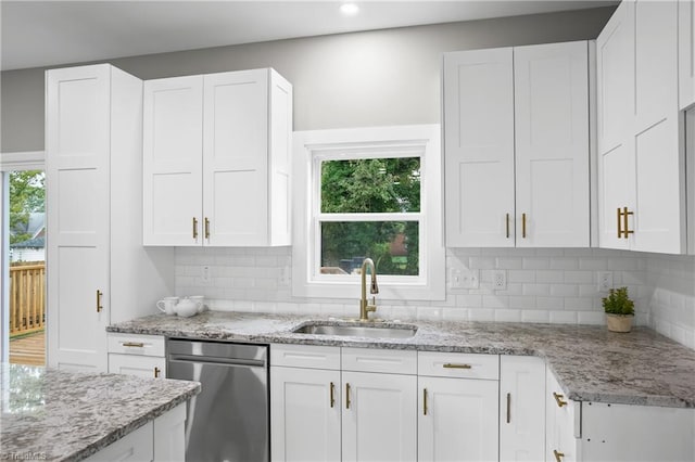 kitchen featuring backsplash, sink, light stone counters, and white cabinets