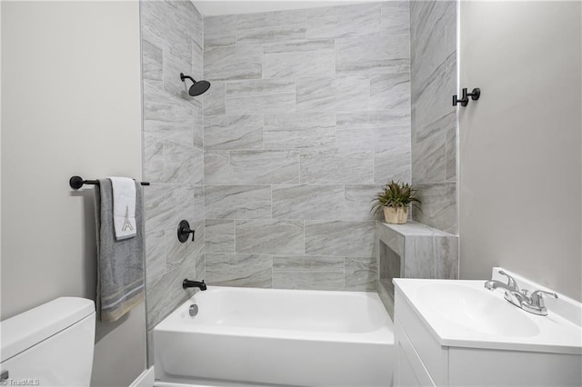 full bathroom with tiled shower / bath, vanity, and toilet