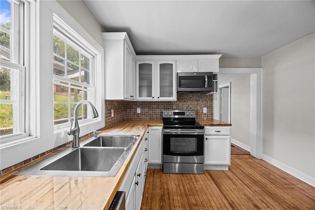 kitchen featuring stainless steel appliances, a sink, and white cabinetry