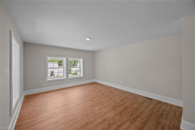 spare room featuring wood finished floors and baseboards