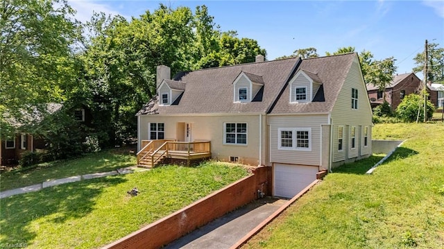 view of front of property featuring an attached garage, a chimney, a wooden deck, driveway, and a front yard