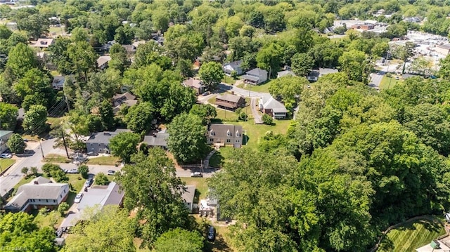 aerial view of property's location featuring nearby suburban area and a forest