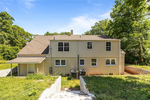 rear view of house featuring central air condition unit, a chimney, and roof with shingles