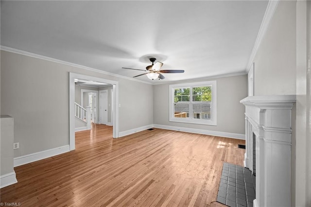 unfurnished living room featuring a fireplace with flush hearth, baseboards, light wood-style floors, a ceiling fan, and crown molding